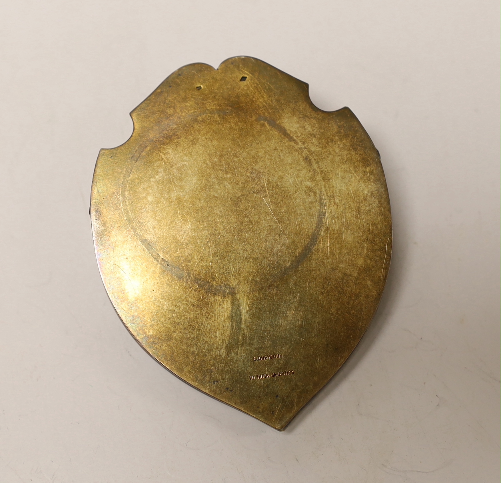 A French gilt white metal (boar's head mark) and enamelled shield shaped desk clip, inscribed 'E. Dreyfous to their Majesties', 78mm.